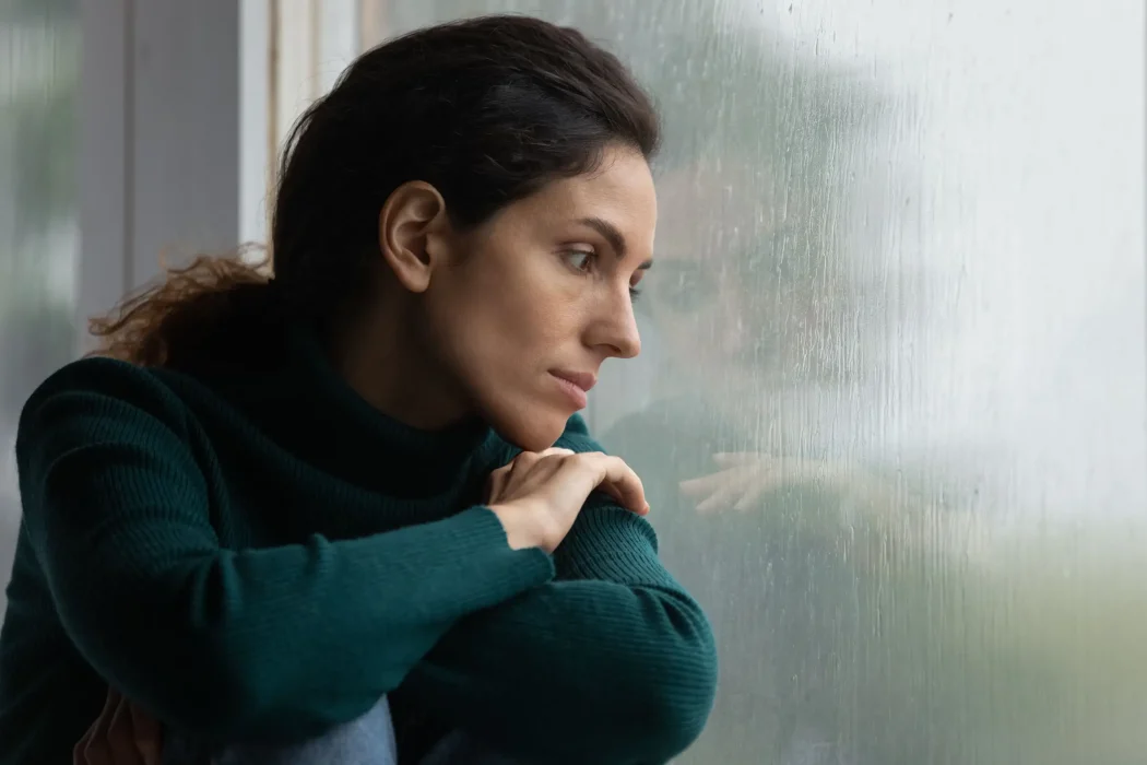 mujer mirando por la ventana